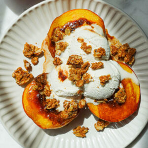 Air fryer peaches topped with vegan vanilla ice cream and granola