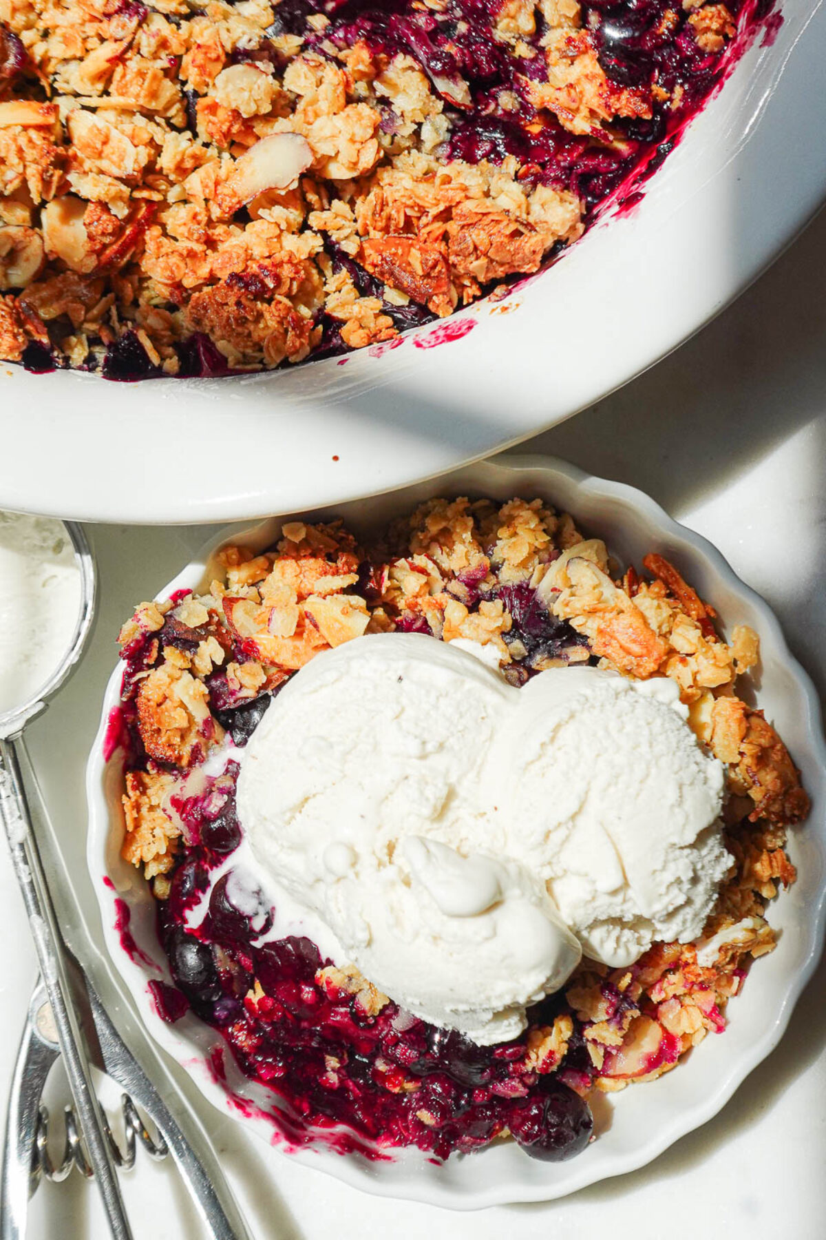 Healthy blueberry crisp served with vegan vanilla ice cream.