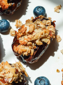 Blueberry Crisp Stuffed Dates on a white plate garnished with fresh blueberries