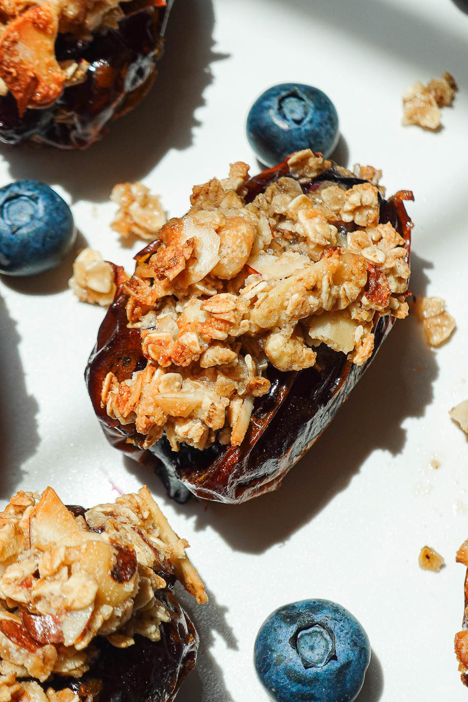 Blueberry Crisp Stuffed Dates on a white plate garnished with fresh blueberries