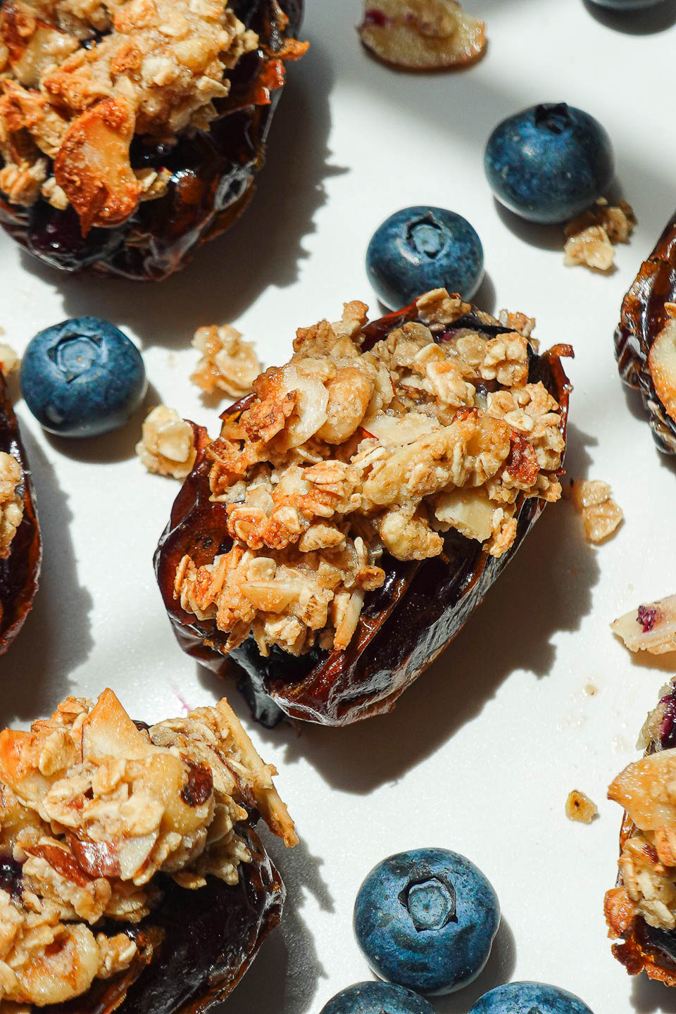Close-up of Blueberry Crisp Stuffed Dates with nutty oat topping on a white plate