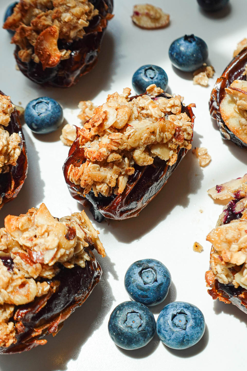 Air-fried Blueberry Crisp Stuffed Dates served with fresh blueberries on a white plate