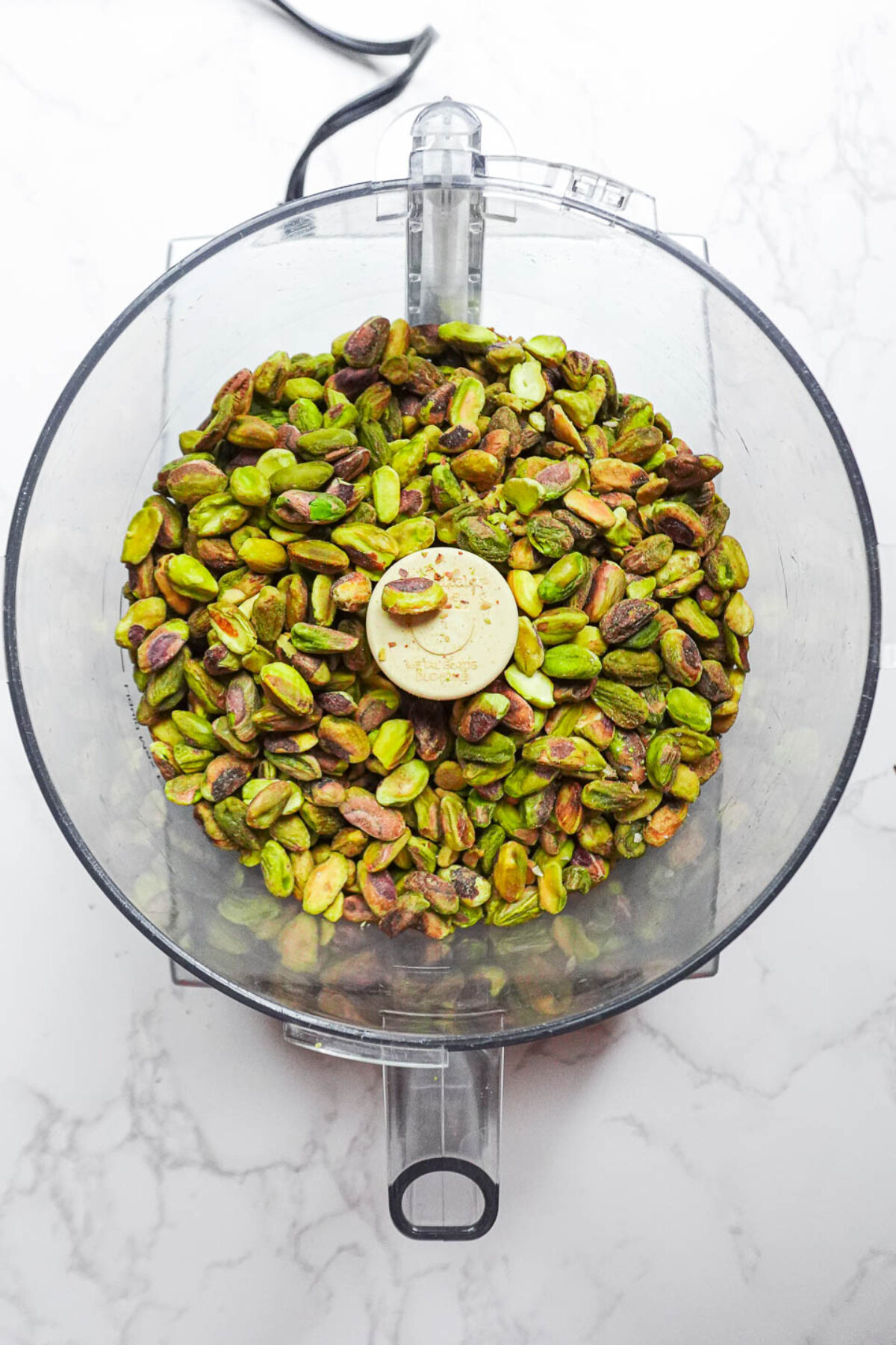 Pistachios in a food processor to make creamy pistachio butter