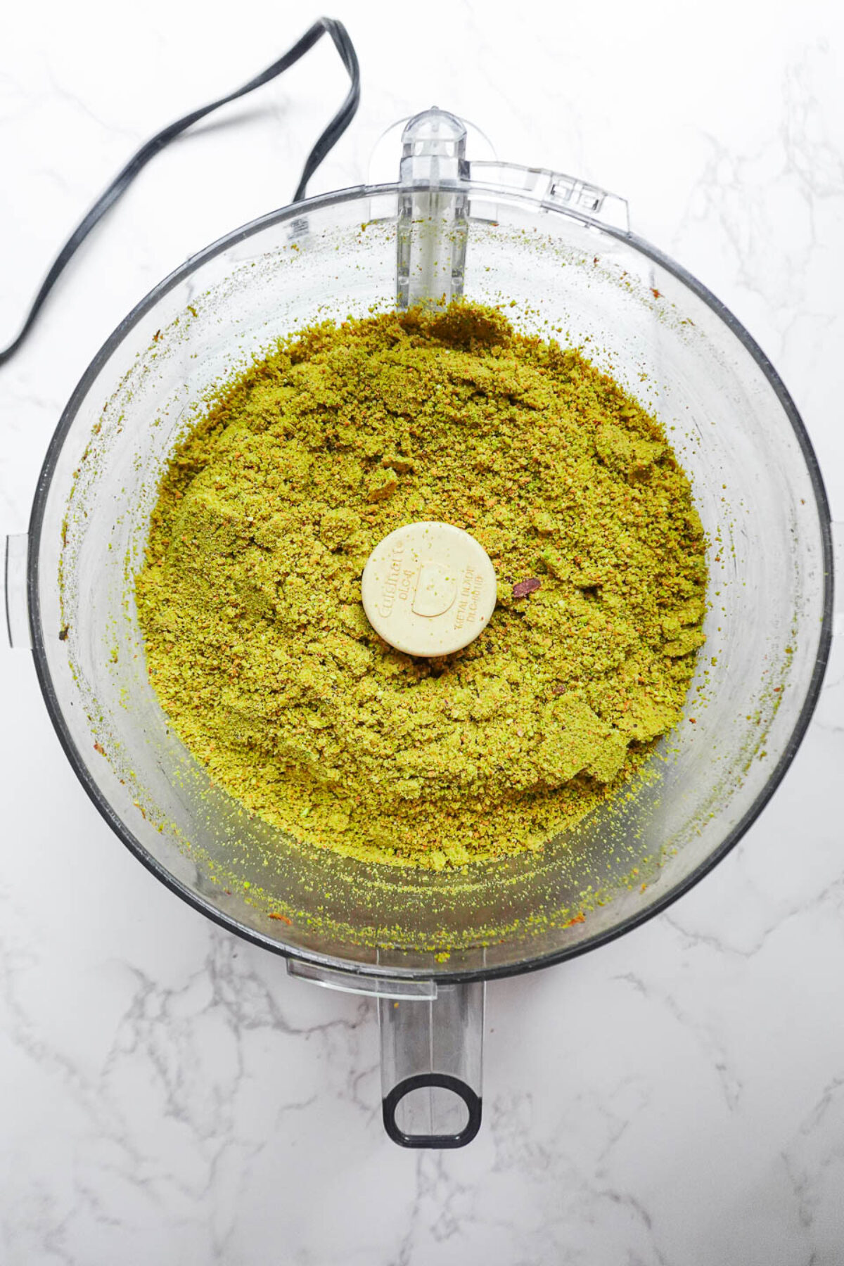 Pistachios blending in a food processor to make creamy pistachio butter
