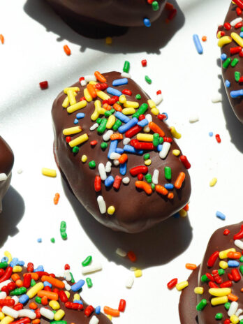 Cosmic brownie stuffed medjool dates with rainbow sprinkles on a white plate
