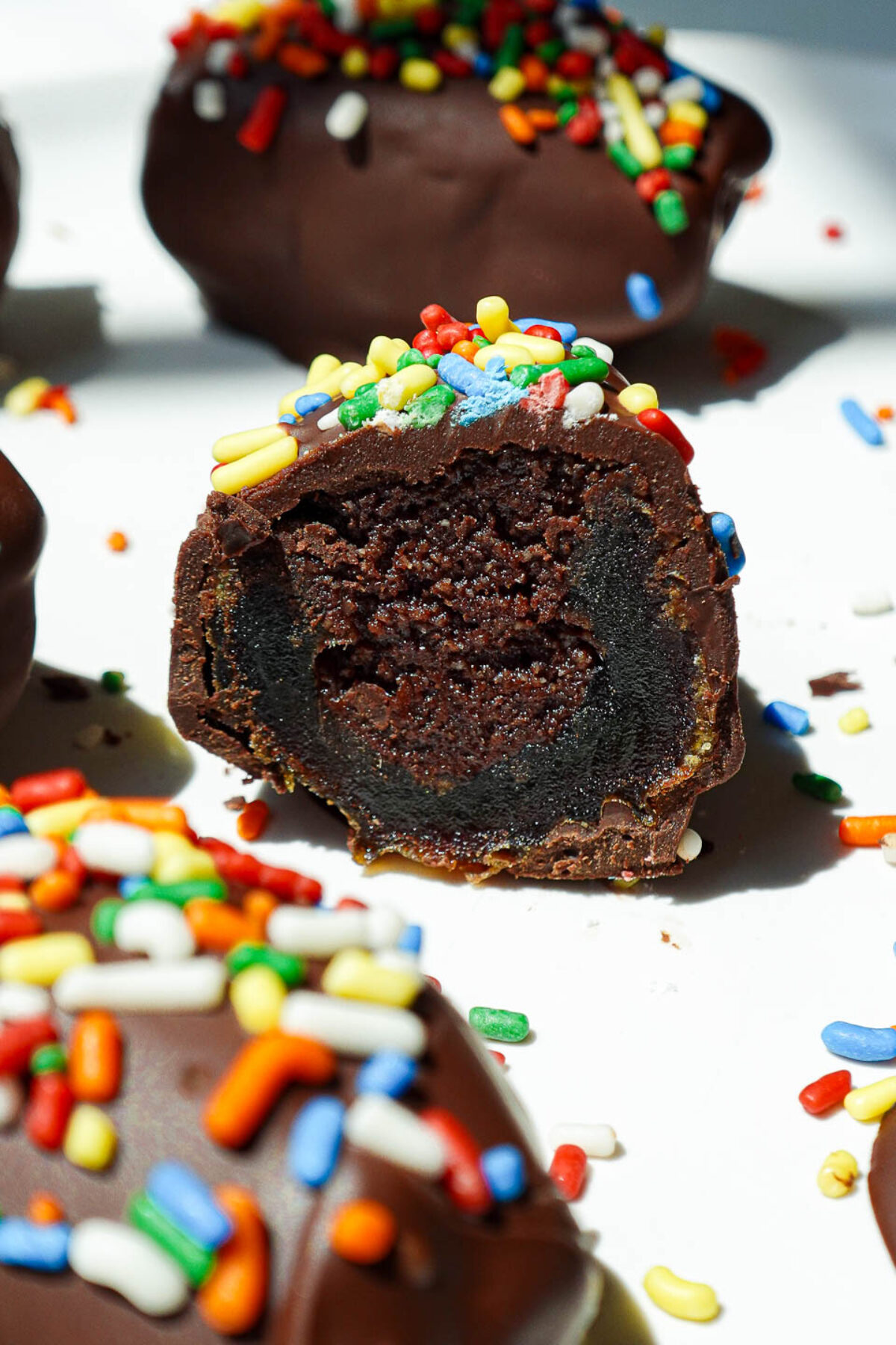 Bite taken out of of cosmic brownie stuffed dates with fudgy filling and sprinkles.