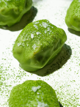 Close up of chewy medjool dates filled with vegan yogurt and dipped in matcha white chocolate