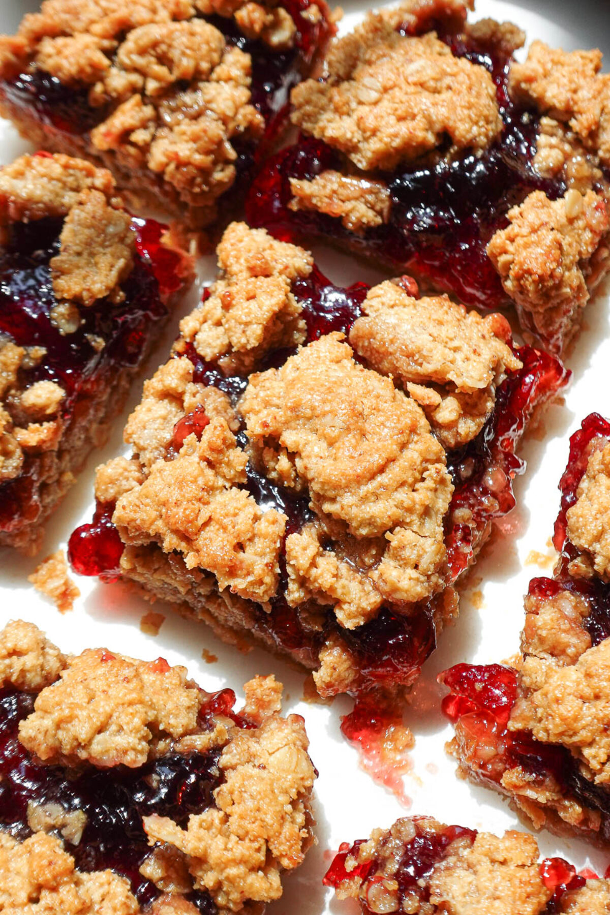 Close-up of a soft, chewy PB&J bar with golden oat crust and jammy center