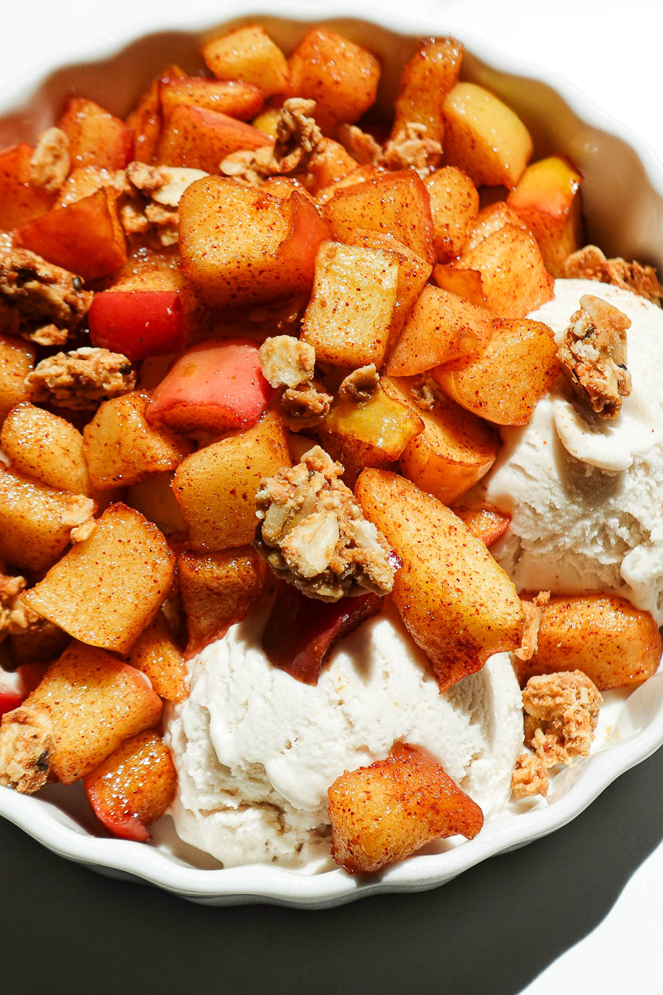 Close-up of air fryer apples topped vanilla ice cream and a sprinkle of crunchy granola