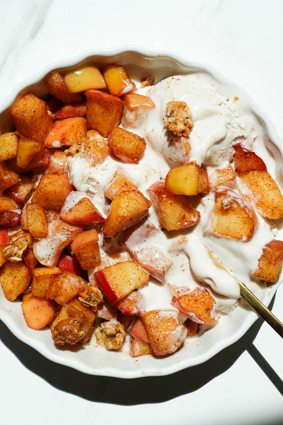 Warm air fryer apples topped with vegan vanilla ice cream and granola.