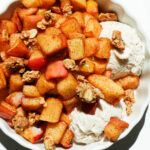 Healthy air fryer apples in a ramekin with vegan ice cream and granola on top
