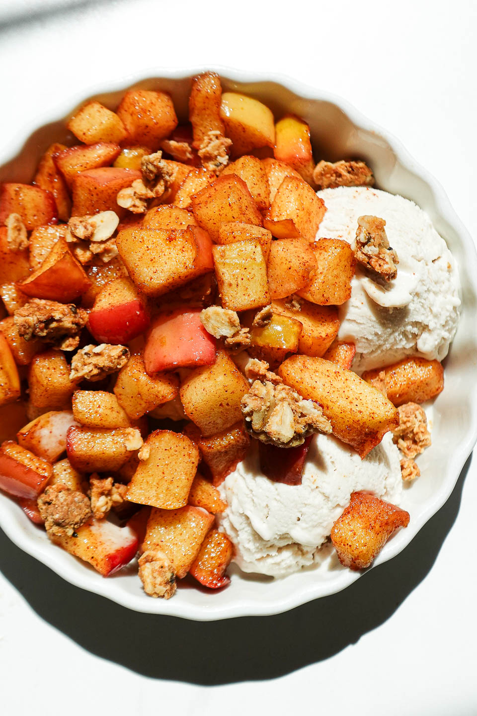 Healthy air fryer apples in a ramekin with vegan ice cream and granola on top