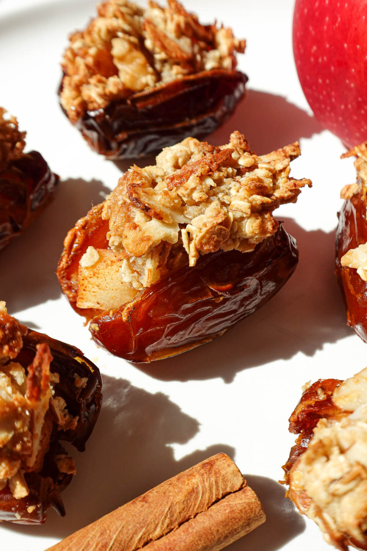 Close-up of a stuffed date showing warm apple filling and crunchy oat topping