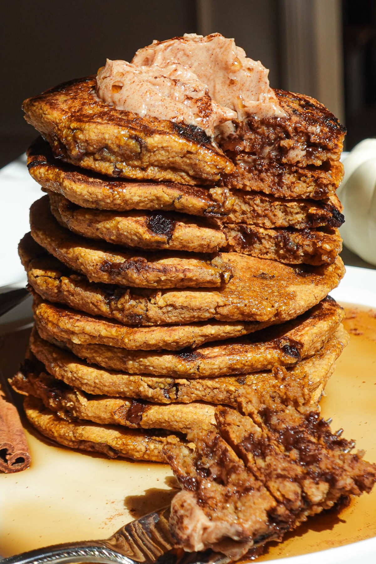 Pumpkin chocolate chip pancakes served with maple syrup and a fork on the side