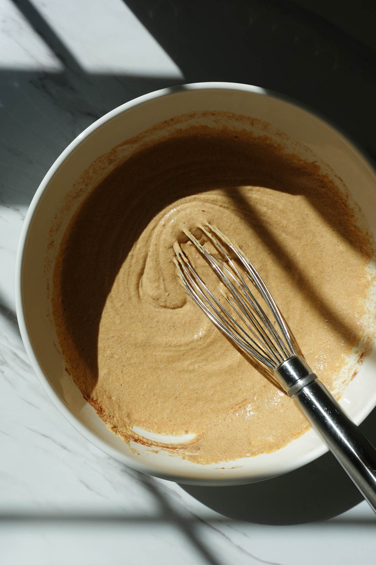 Whisking batter to make vegan pumpkin pancakes.