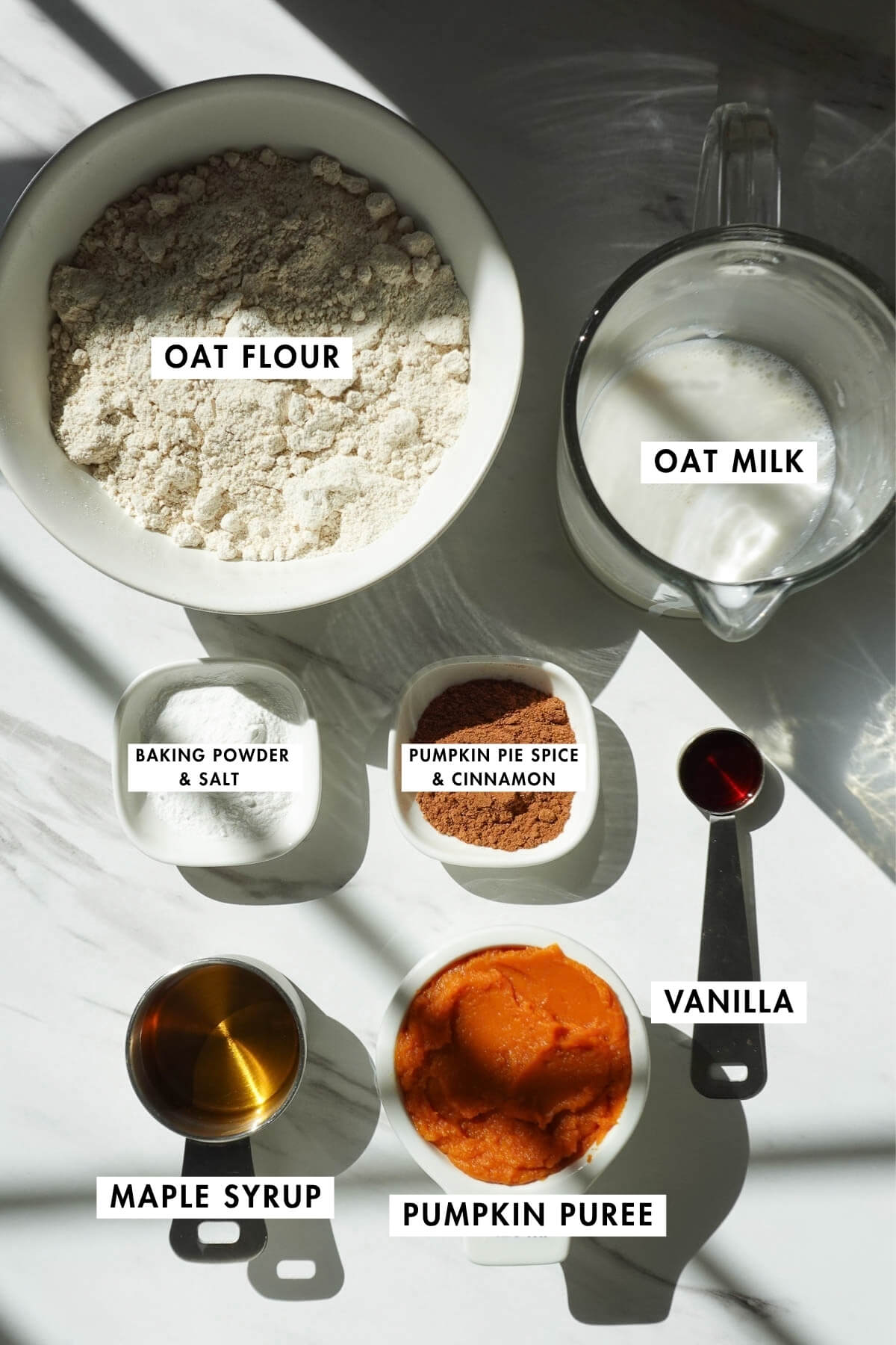 Ingredients for vegan pumpkin pancakes arranged on a kitchen counter.
