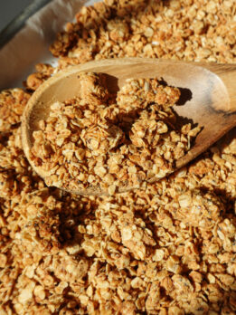 Healthy peanut butter granola with big crunchy clusters on a baking sheet