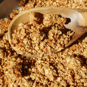 Healthy peanut butter granola with big crunchy clusters on a baking sheet