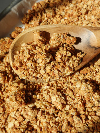 Healthy peanut butter granola with big crunchy clusters on a baking sheet