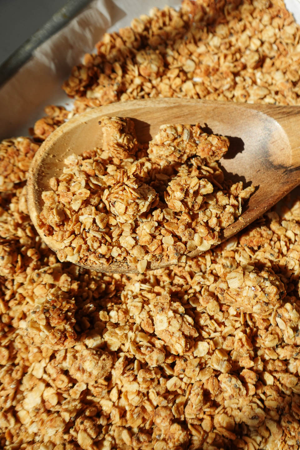 Healthy peanut butter granola with big crunchy clusters on a baking sheet