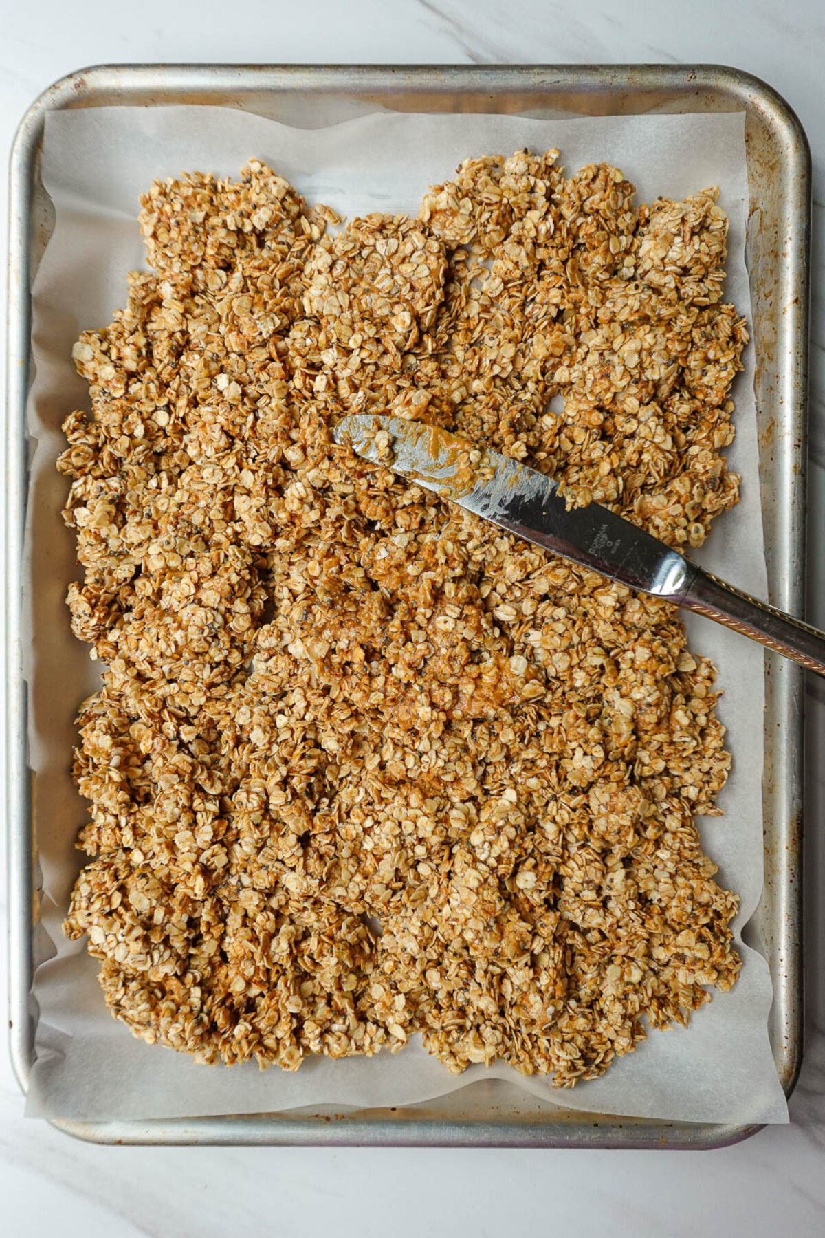 Peanut butter granola on a baking sheet before baking.