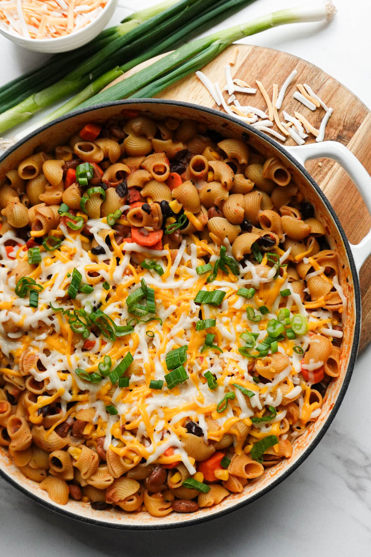 vegan chili mac and cheese made in one-pot and topped with melted vegan cheese and scallions
