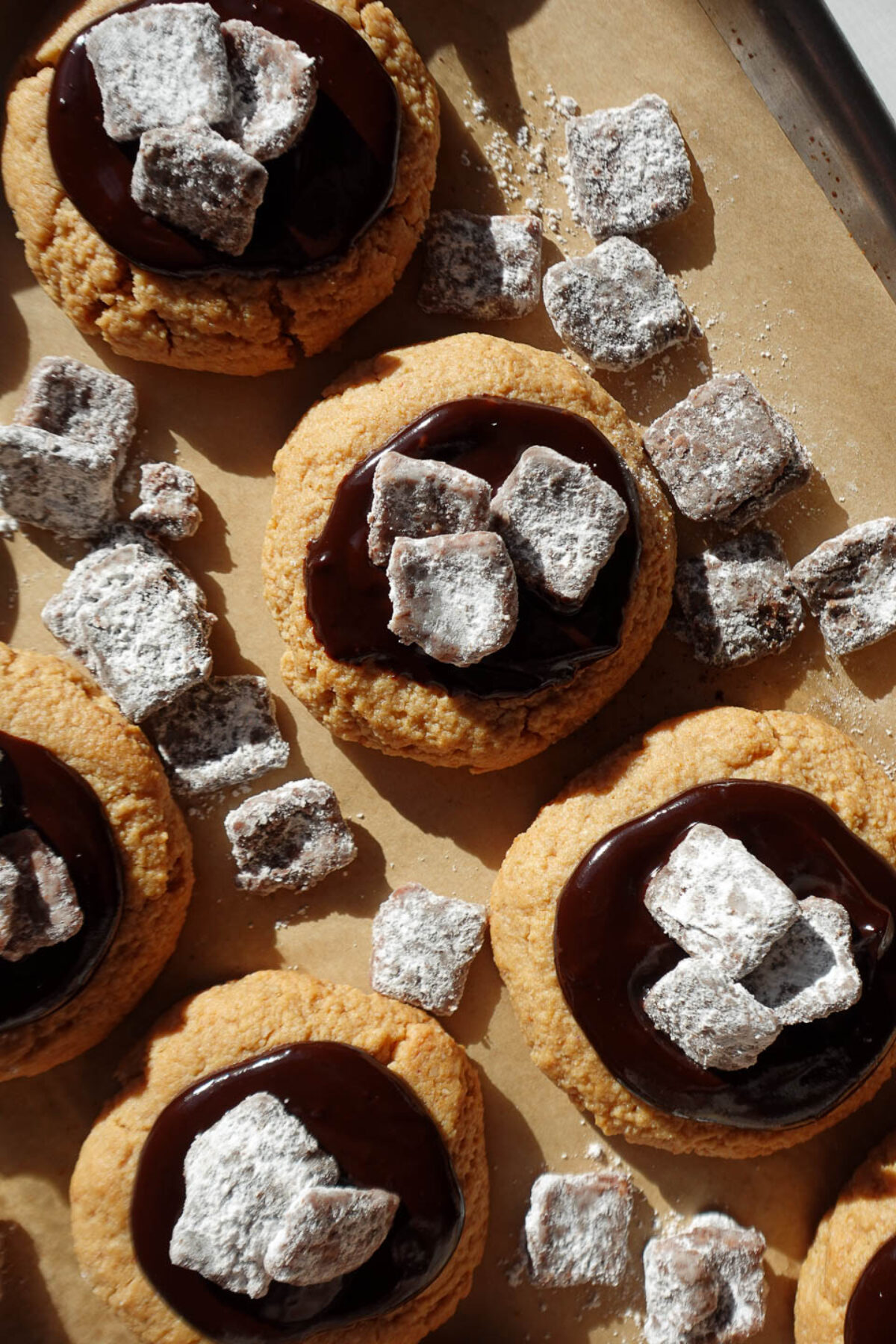 Vegan and gluten-free muddy buddy cookies topped with chocolate ganache and crunchy muddy buddy pieces