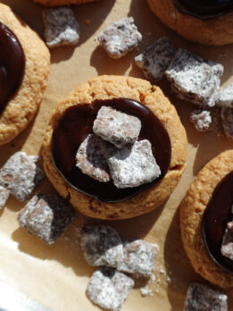 Close-up of a muddy buddy cookie with soft peanut butter cookie base and chocolate ganache