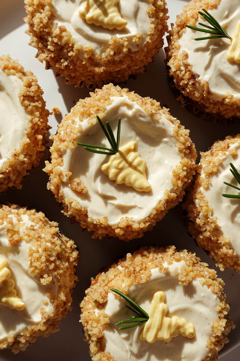 cutely decorated healthy carrot cake muffins topped with high-protein vegan cream cheese frosting. gluten-free, too!
