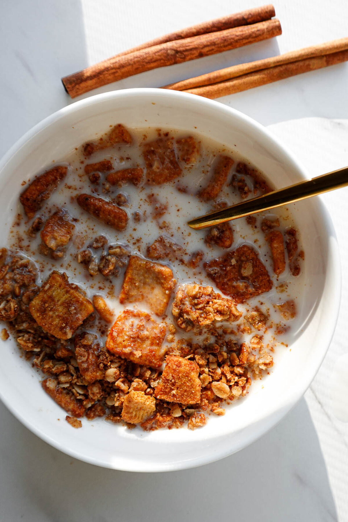 Cinnamon Toast Crunch–style granola served in a bowl as cereal with oat milk.