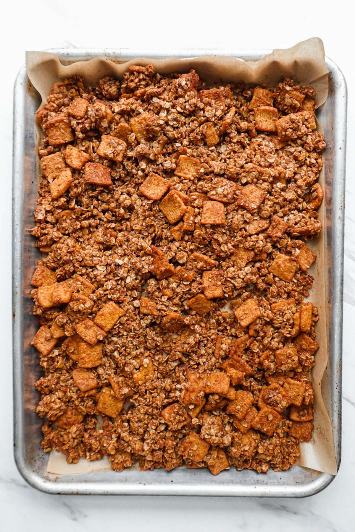 Vegan cinnamon toast crunch granola on a baking sheet after baking.