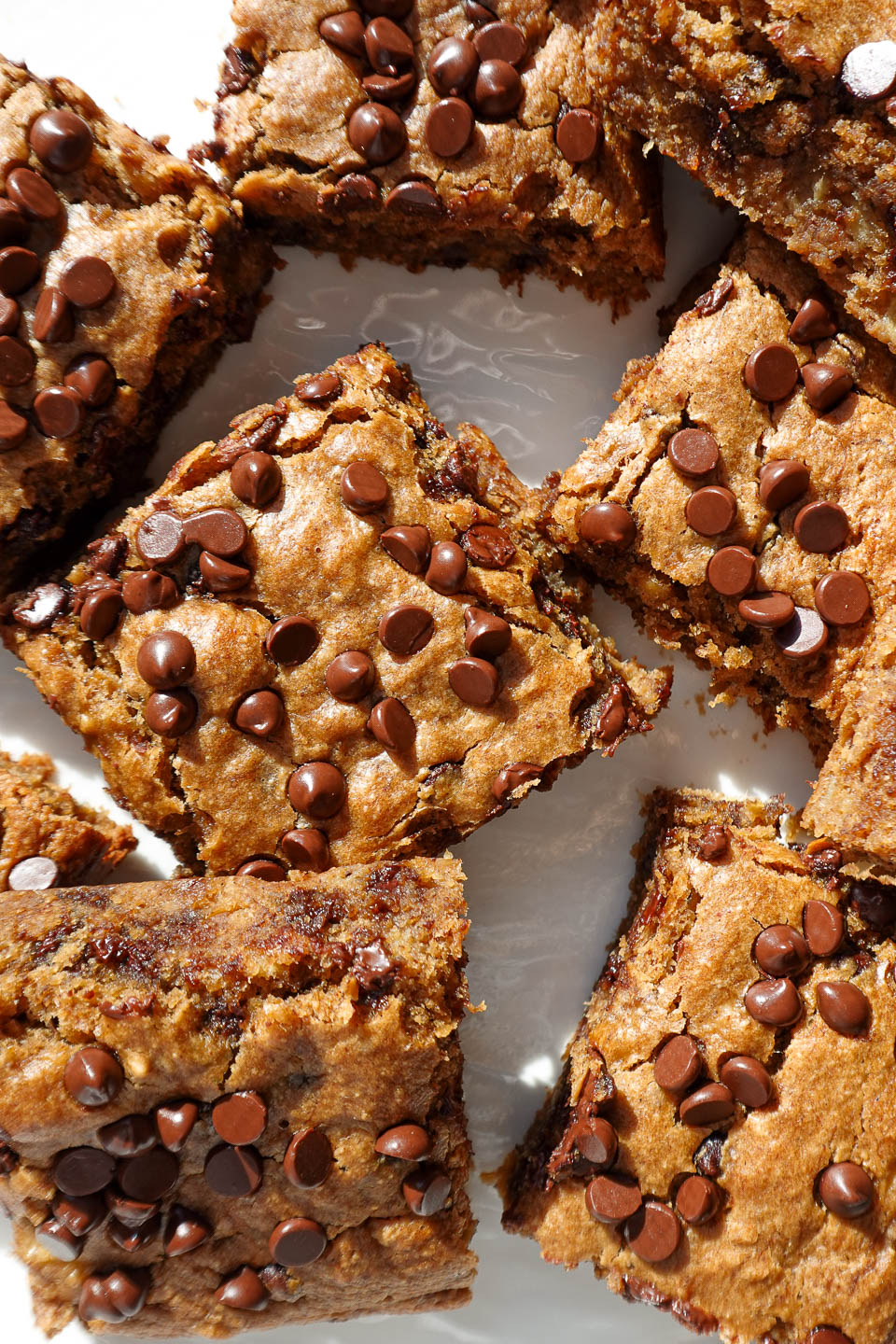 overhead shot soft and moist vegan chocolate chip banana bars with mini chocolate chips on a white plate