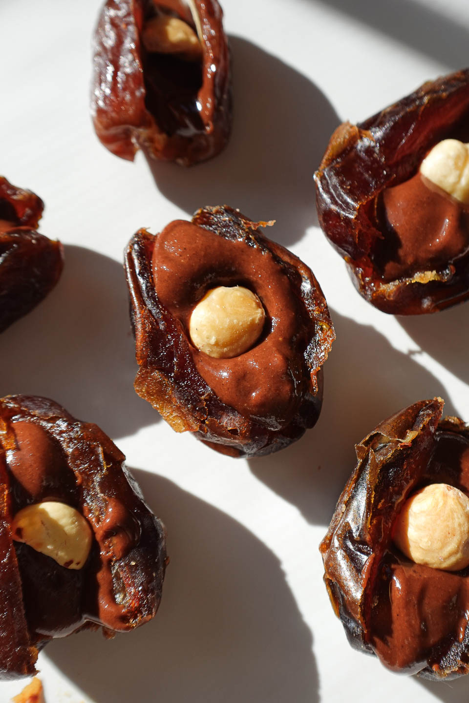 Whole hazelnut pressed into chocolate hazelnut filling inside a medjool date.