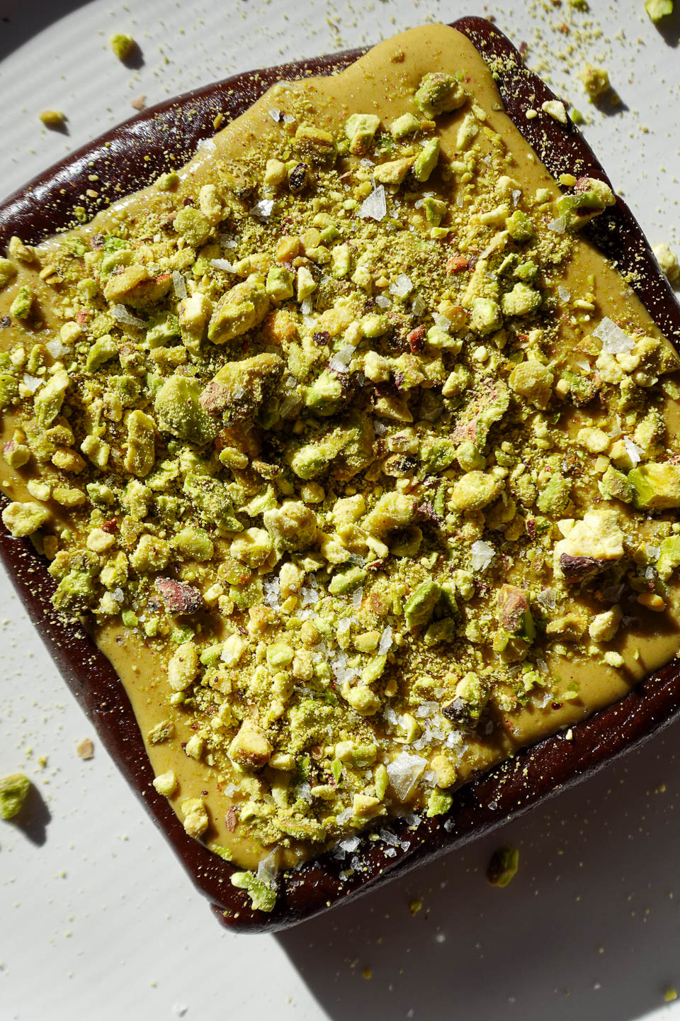 No bake pistachio brownies topped with pistachio butter and chopped pistachios