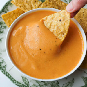 Nut-free vegan cheese sauce served as a queso dip with tortilla chips