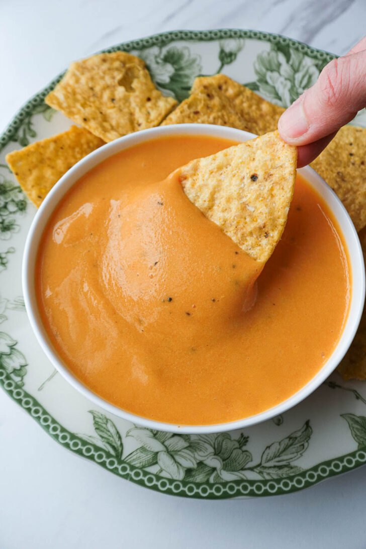 Nut-free vegan cheese sauce served as a queso dip with tortilla chips