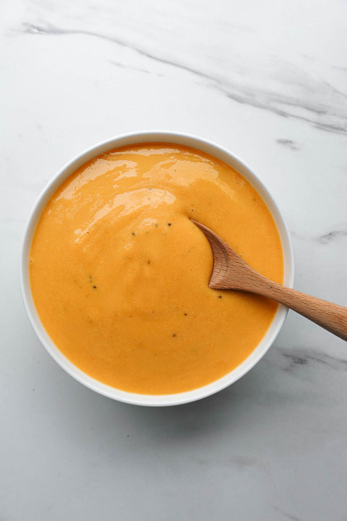 nut-free vegan cheese sauce made with potatoes and carrots in a white bowl