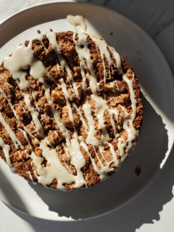 Drizzling dairy-free icing over baked carrot cake coffee cake