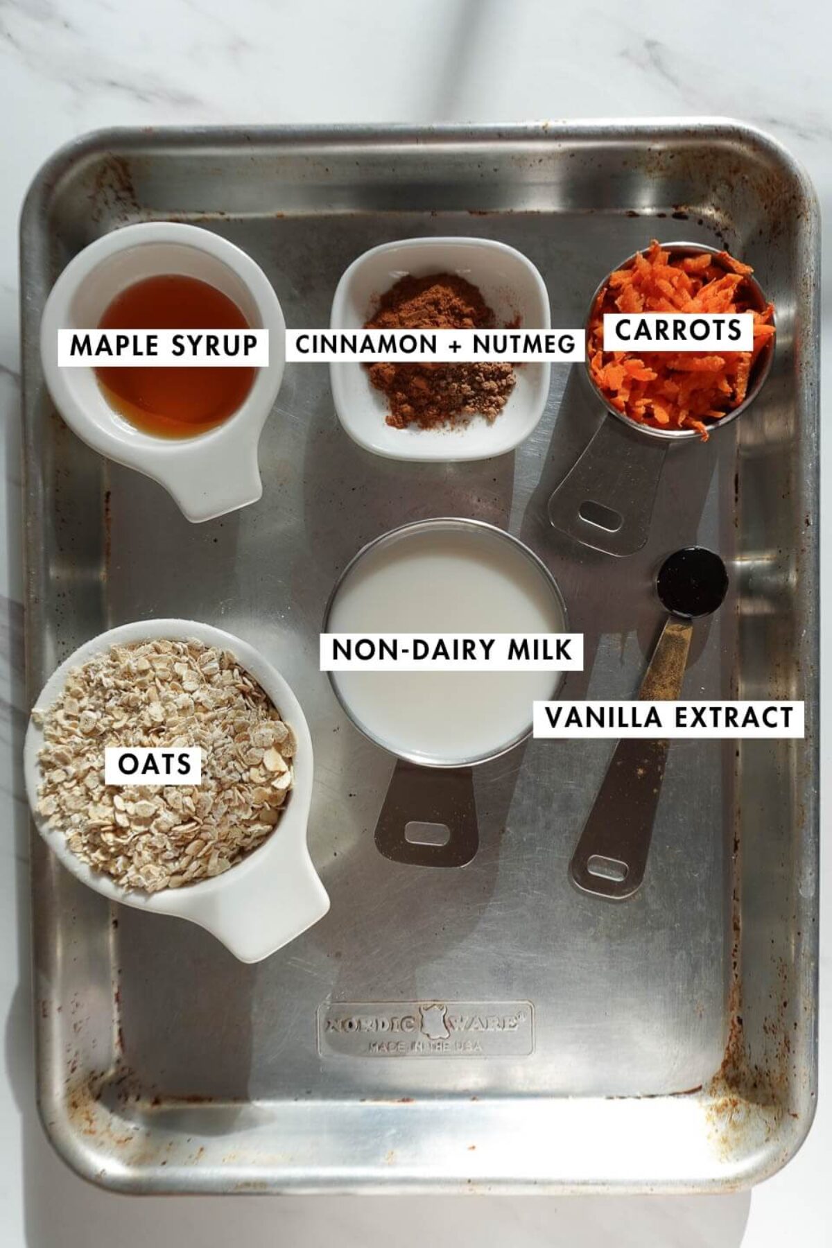 Carrot cake overnight oats ingredients including oats, grated carrots, non-dairy milk, maple syrup, and spices