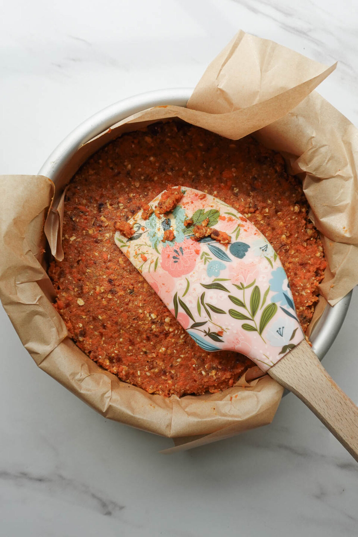 Pressing no bake carrot cake mixture into lined pan