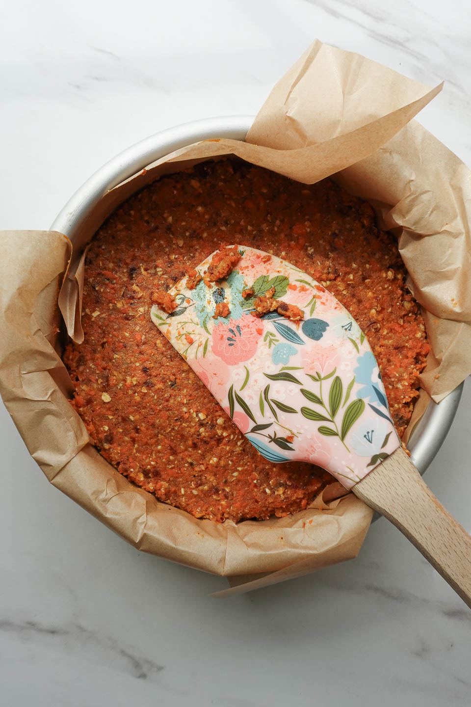 Pressing no bake carrot cake mixture into lined pan