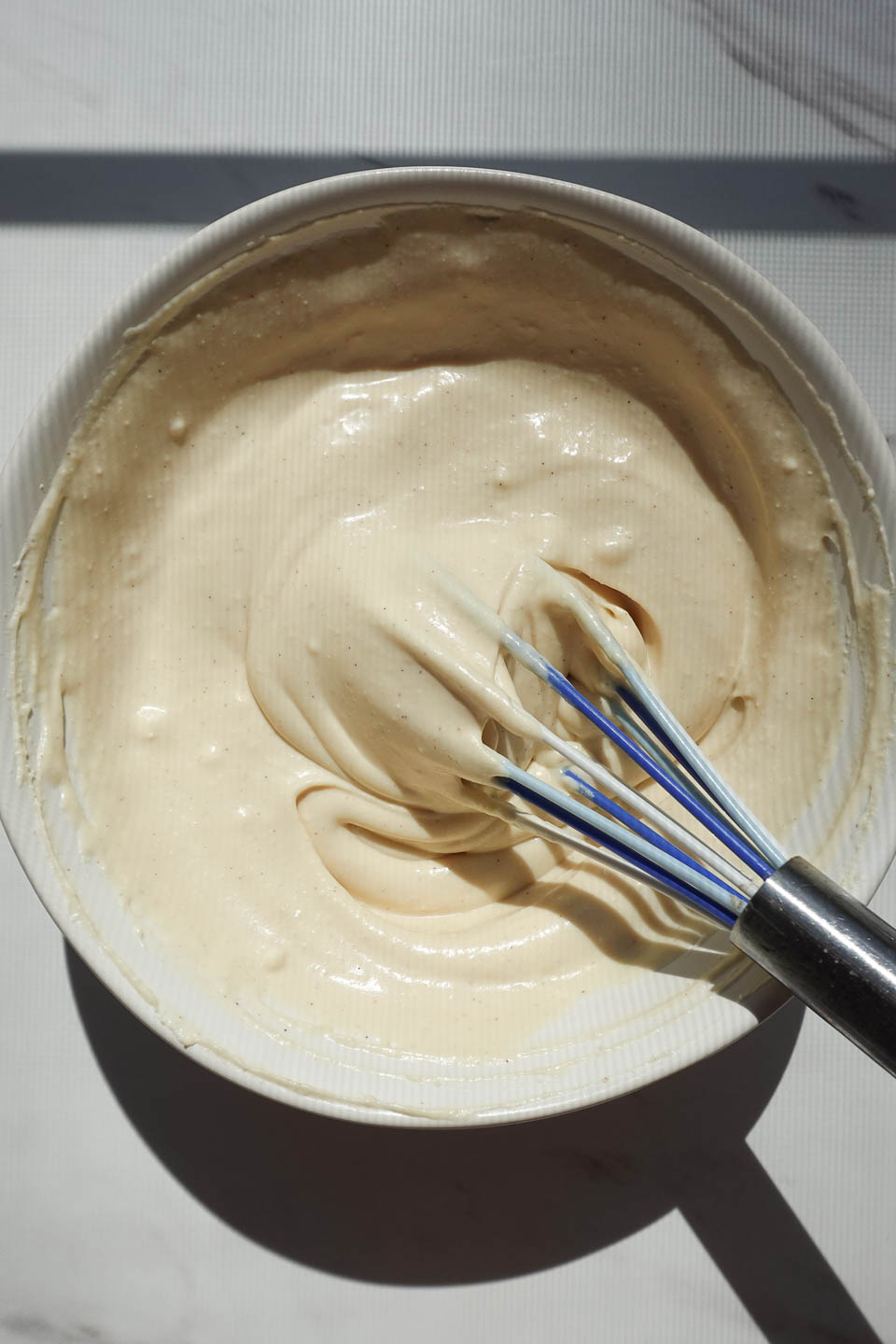 whisking vegan cream cheese frosting for raw carrot cake