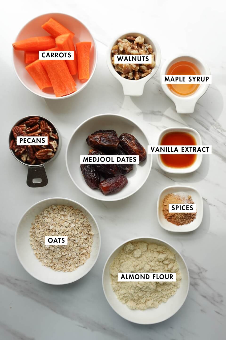 Ingredients for no bake carrot cake including dates, carrots, oats, and walnuts