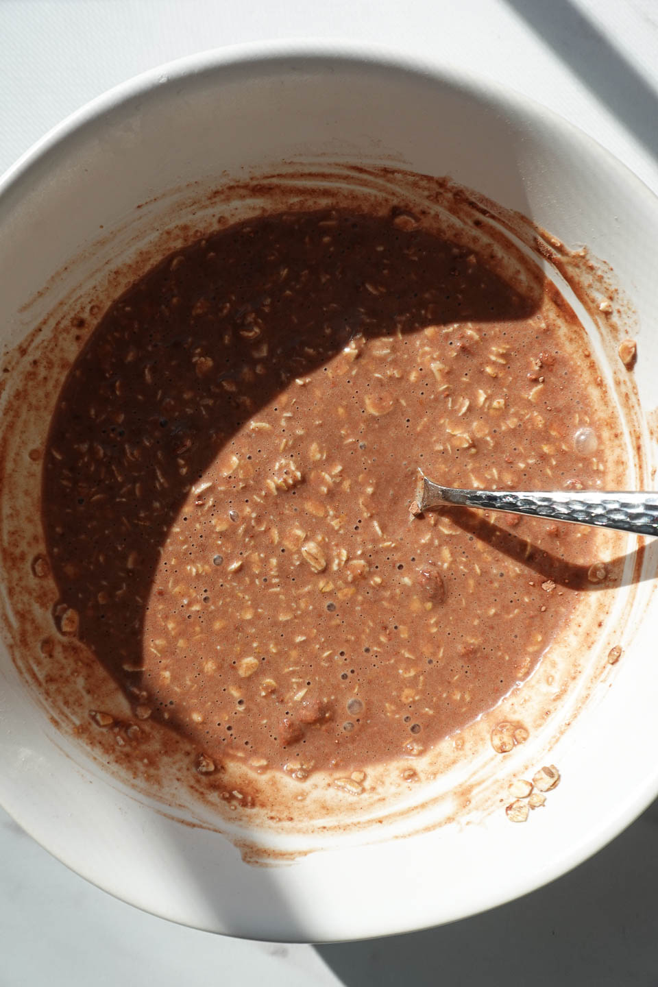 Stirring chocolate coconut overnight oats before chilling