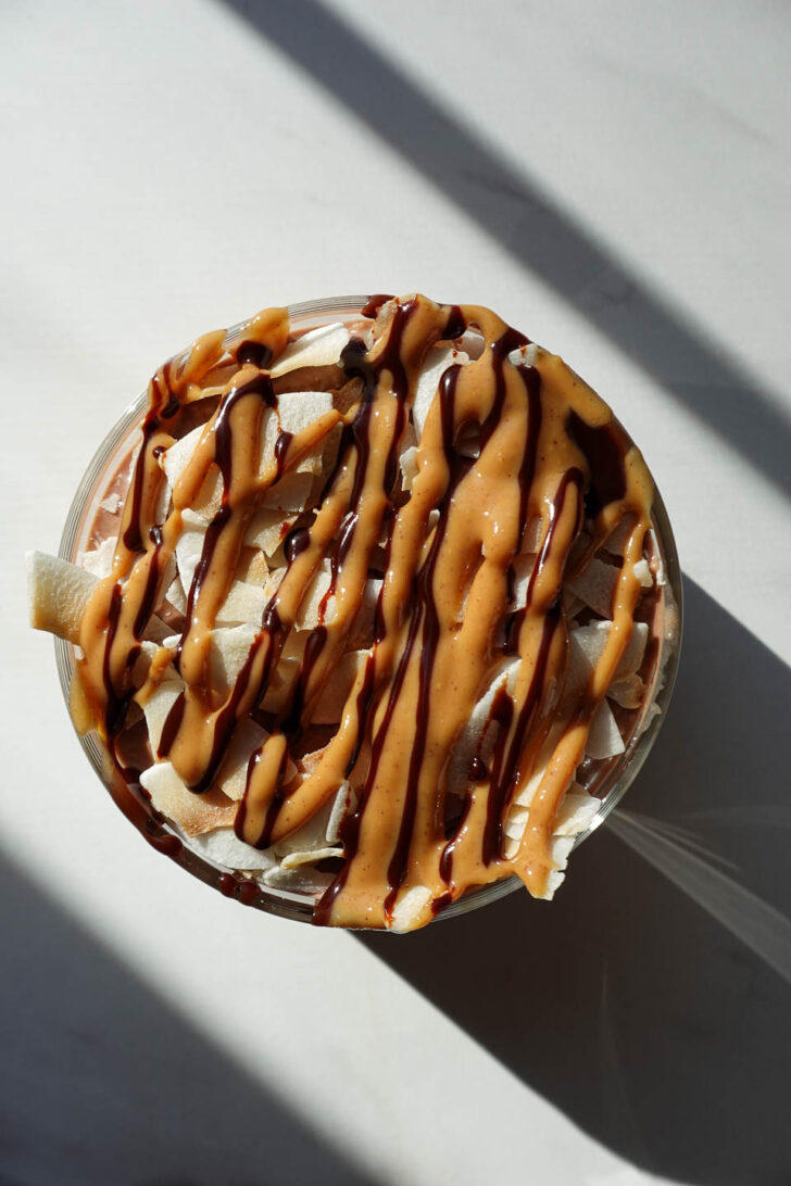 Overhead view of Samoas overnight oats topped with chocolate and nut butter