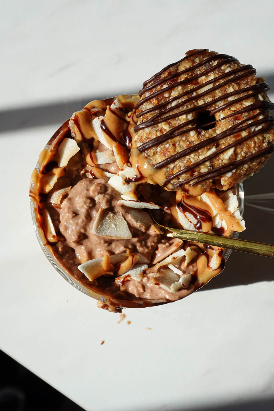 Overhead view of Samoas overnight oats drizzled with chocolate syrup, peanut butter, and topped with a samoas cookie
