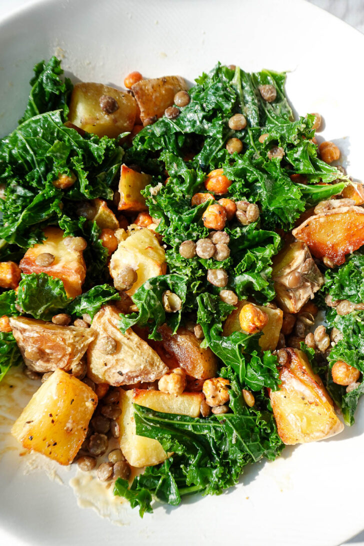 Healthy vegan lentil bowl with roasted potatoes, kale, and crispy chickpeas