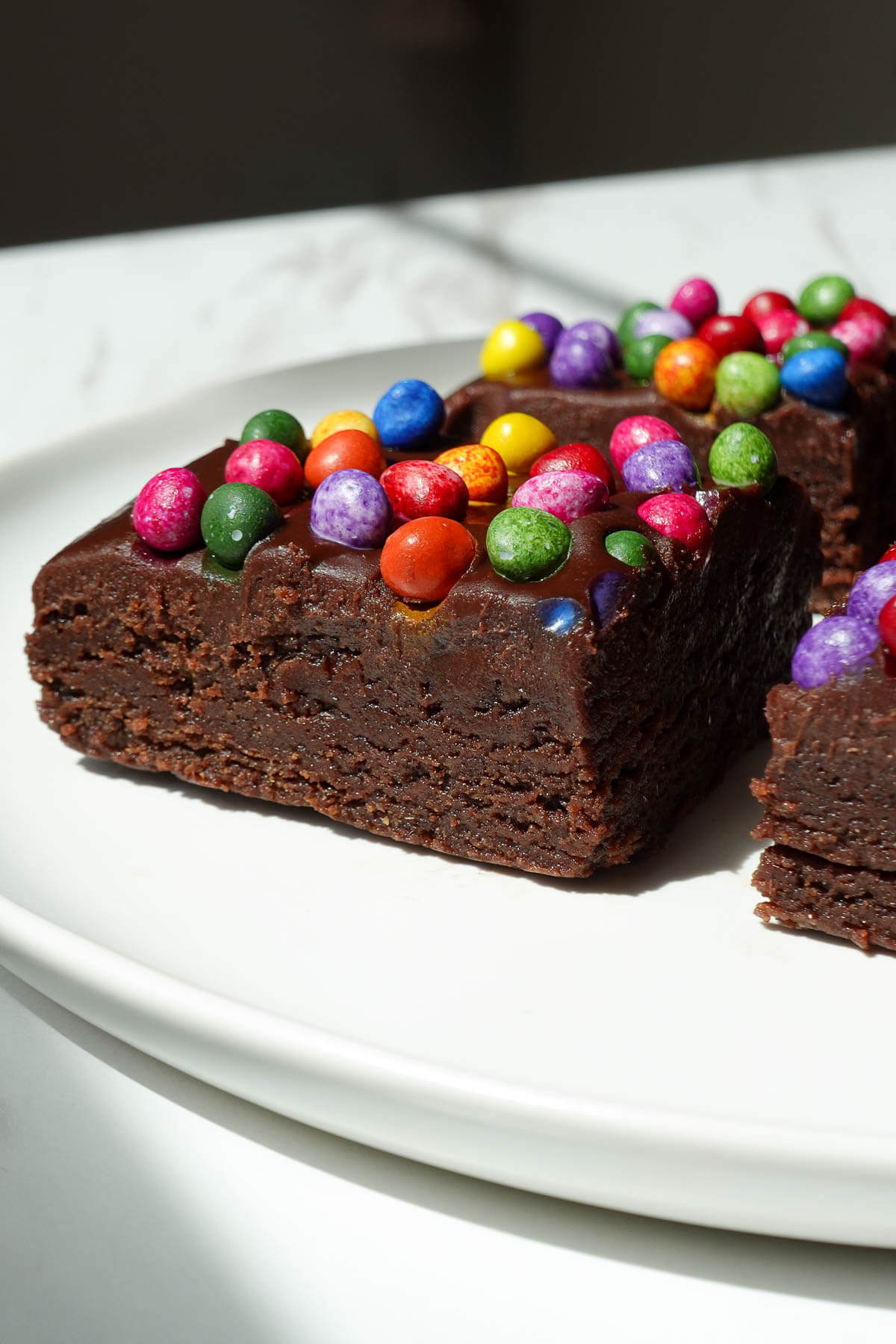 Side view of no bake cosmic brownie showing it's thick, fudgy, and rich texture.