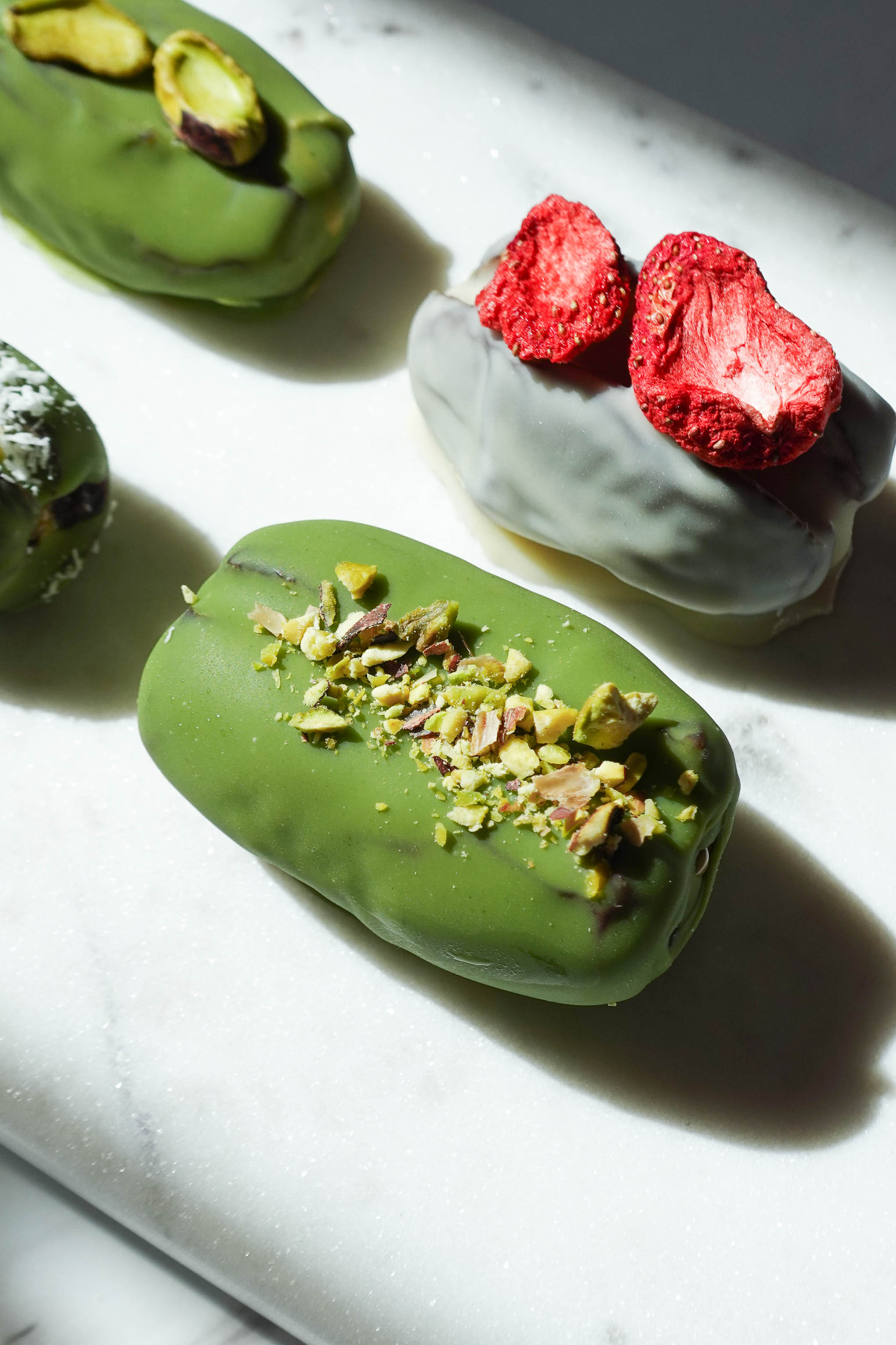 Pistachio matcha stuffed date topped with chopped pistachios.