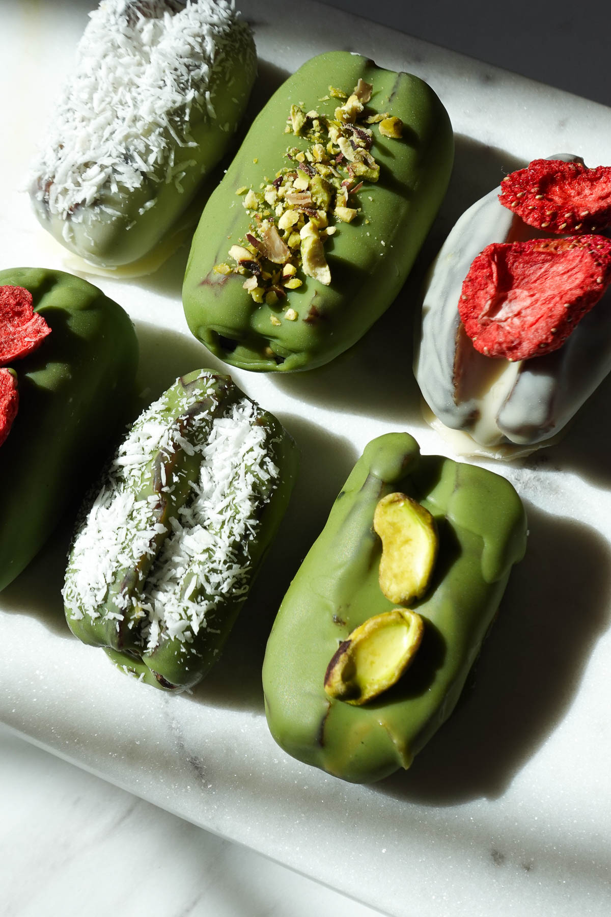 Pistachio matcha stuffed dates topped with chopped pistachios, shredded coconut, and freeze dried strawberries.